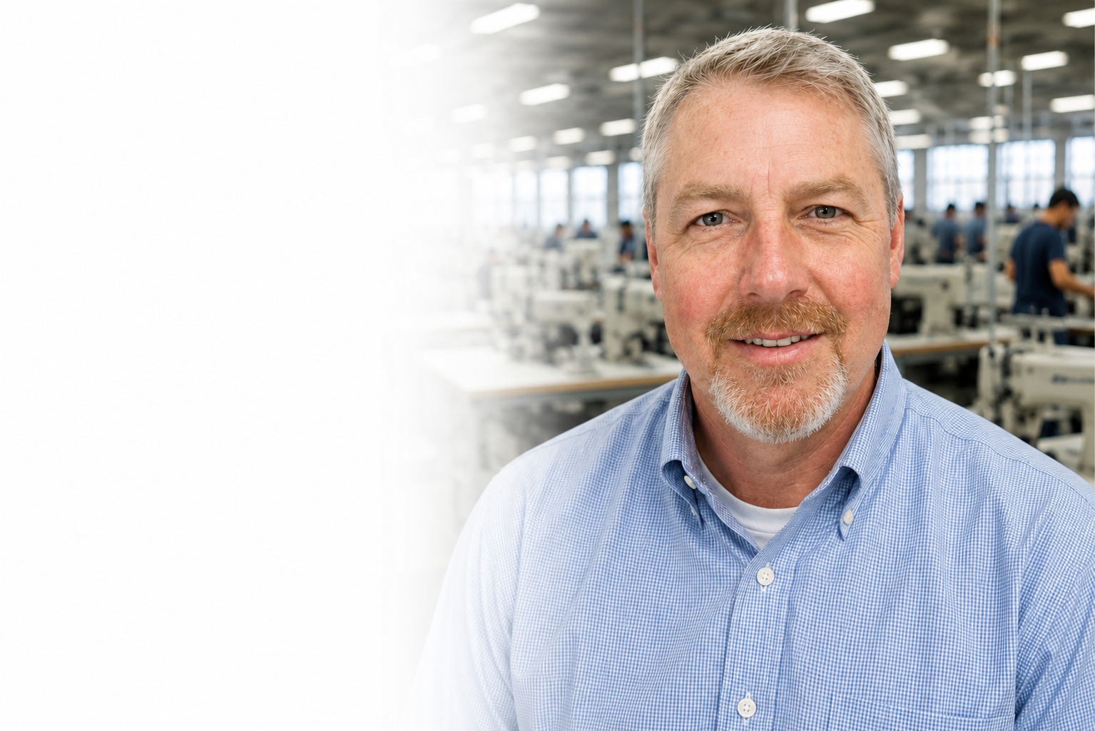 Greg Hathcox smiling on the sewn products factory floor, with sewing machine operators at work in the background